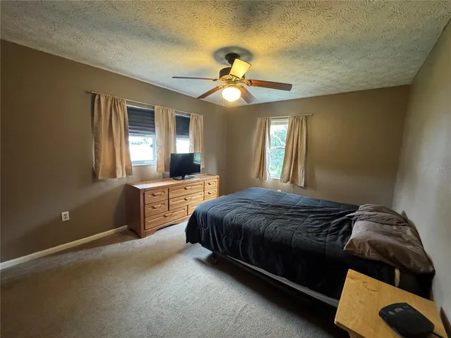 a bedroom with a bed and a ceiling fan