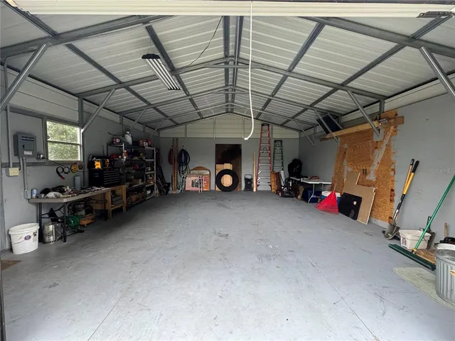 a view of a house with a small yard and large tree