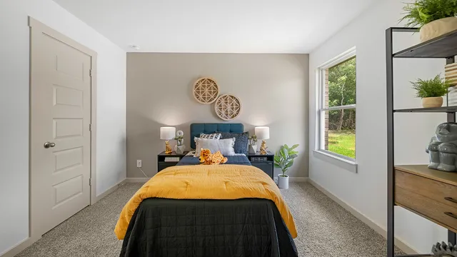 a bed sitting in a bedroom next to a window