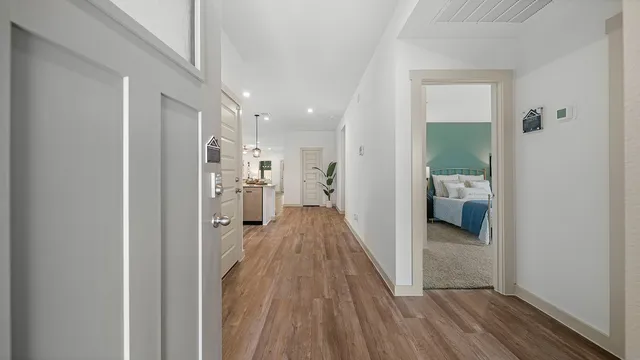 a view of a hallway with wooden floor and a living room