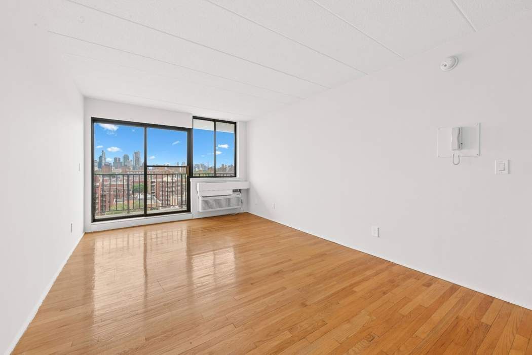 23-22 30th Road, Unit 10H Queens, NY 11102 - Photo 3 of 16 a view of empty room with wooden floor and fan