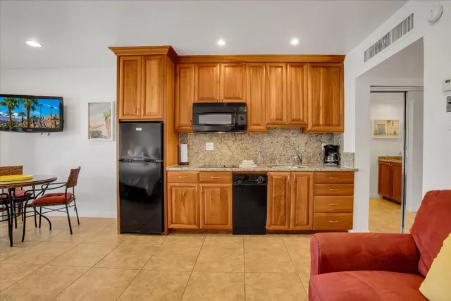 a kitchen with stainless steel appliances granite countertop a granite counter tops and a refrigerator