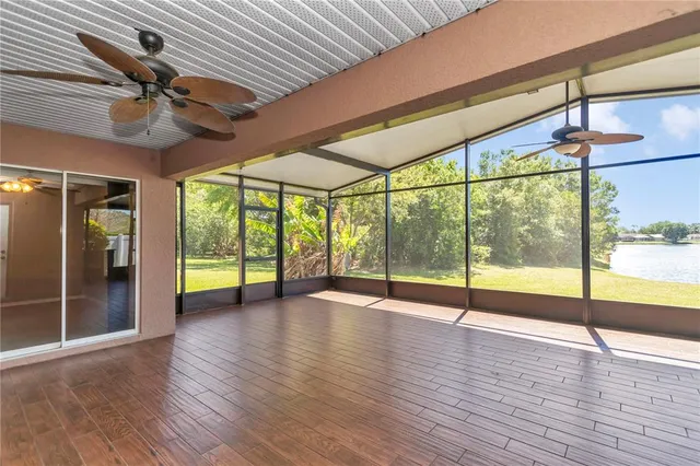 a view of an empty room with wooden floor and a floor to ceiling window