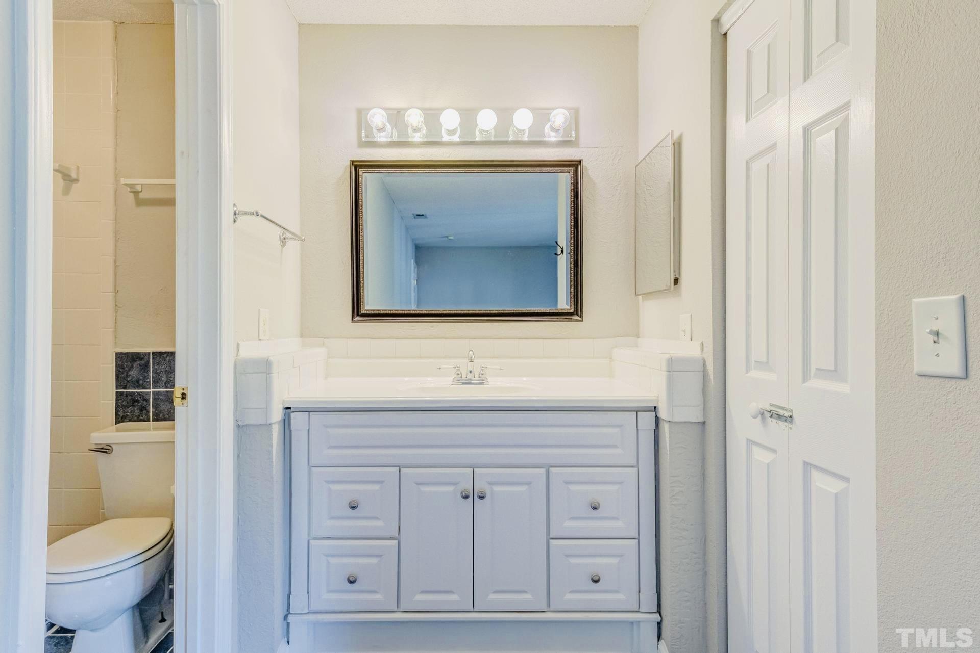 7913 Falcon Rest Circle Raleigh, NC 27615 - Photo 17 of 22 a bathroom with a toilet sink and mirror