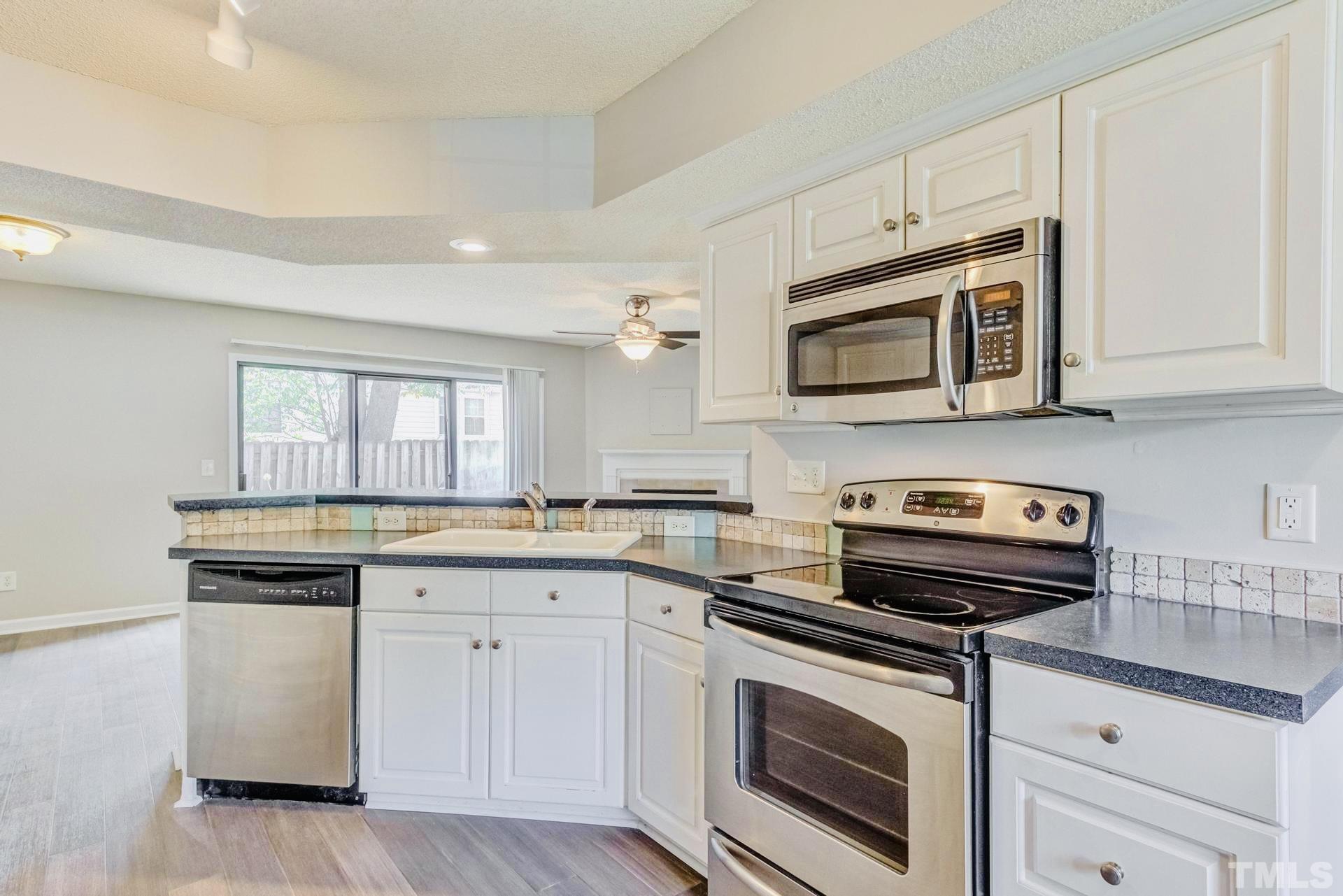 7913 Falcon Rest Circle Raleigh, NC 27615 - Photo 8 of 22 a kitchen with cabinets stainless steel appliances and a sink