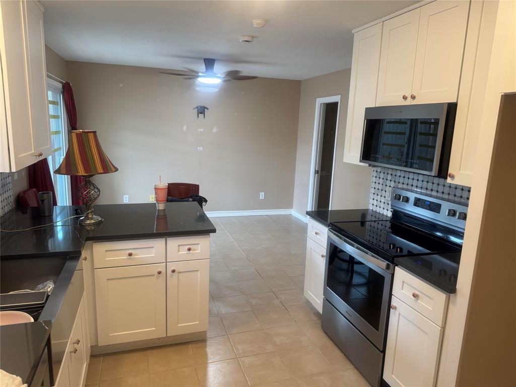 4649 Misty Ridge Drive Fort Worth, TX 76137 - Photo 23 of 25 a kitchen with a stove and a microwave