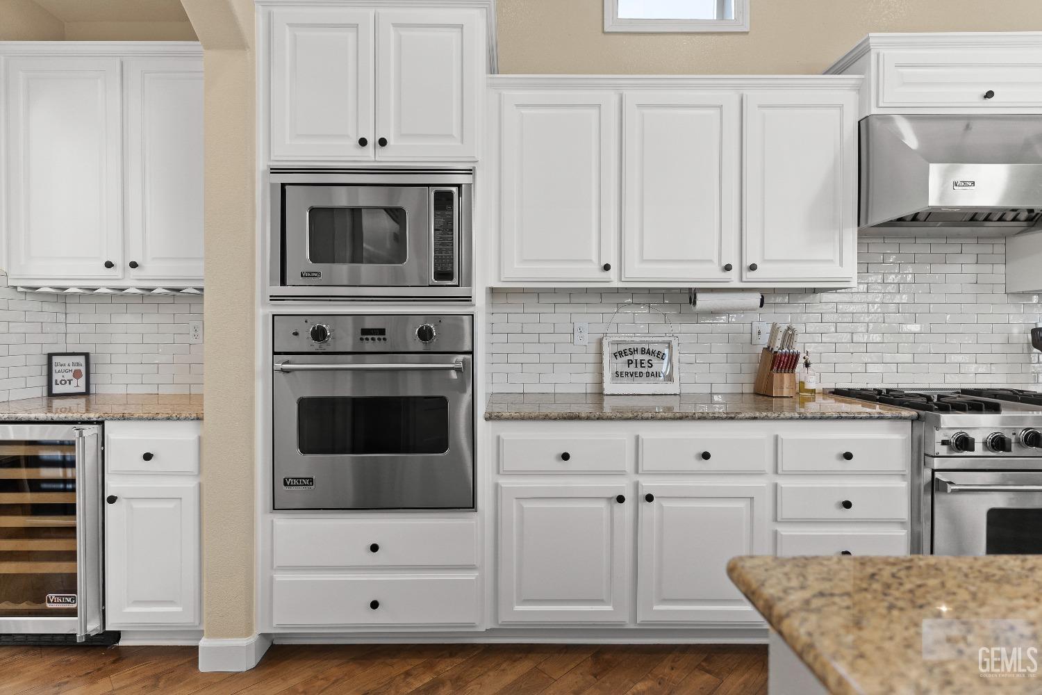 Undisclosed Address Bakersfield, CA 93314 - Photo 16 of 46 a kitchen with granite countertop white cabinets and white appliances