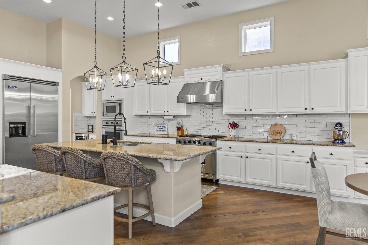 Undisclosed Address Bakersfield, CA 93314 - Photo 23 of 46 a large kitchen with cabinets a sink stainless steel appliances and a chandelier