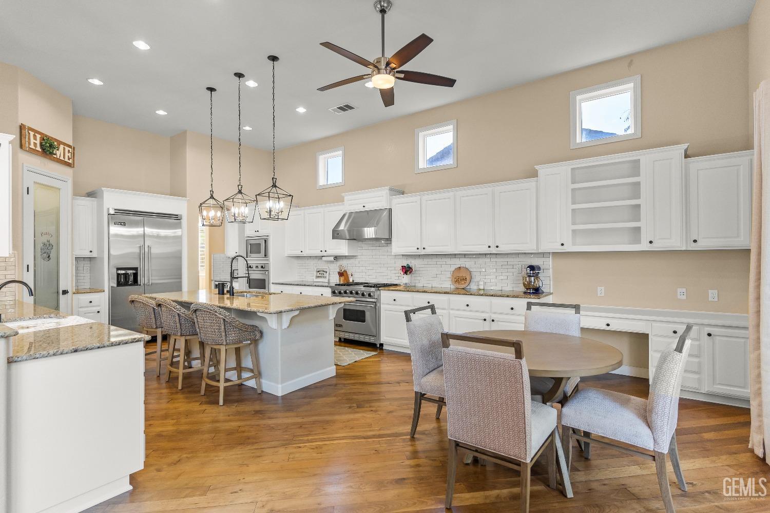 Undisclosed Address Bakersfield, CA 93314 - Photo 29 of 46 a kitchen with a dining table chairs stainless steel appliances and cabinets