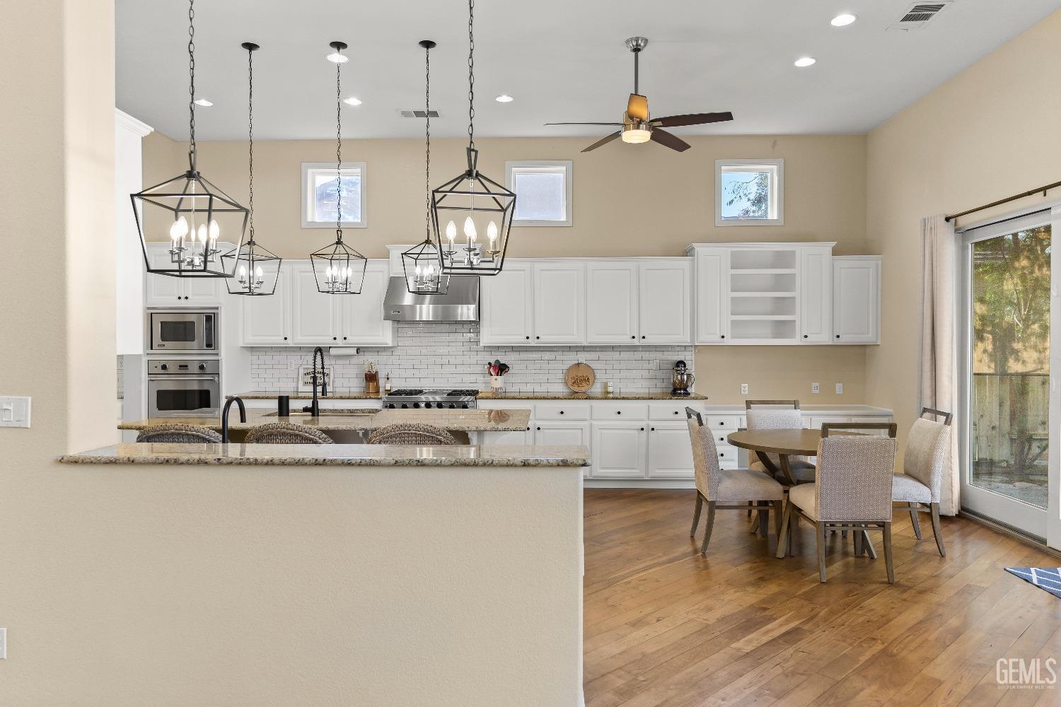 Undisclosed Address Bakersfield, CA 93314 - Photo 30 of 46 a kitchen with stainless steel appliances kitchen island a table and chairs in it