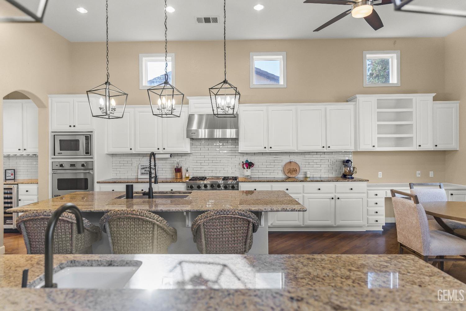 Undisclosed Address Bakersfield, CA 93314 - Photo 32 of 46 a kitchen with stainless steel appliances kitchen island granite countertop a sink and cabinets