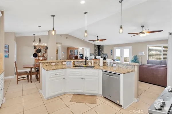 a kitchen with kitchen island a sink a stove and a chandelier