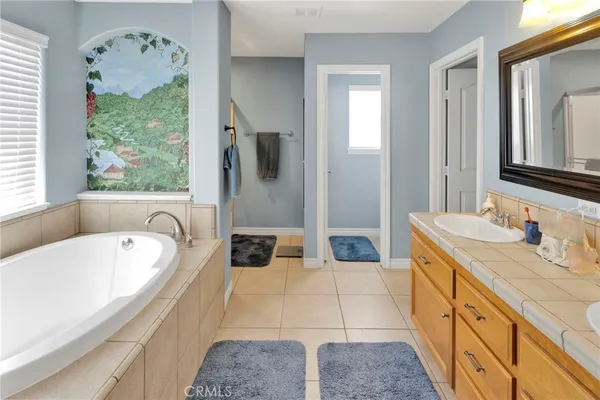 a spacious bathroom with a tub sink and mirror
