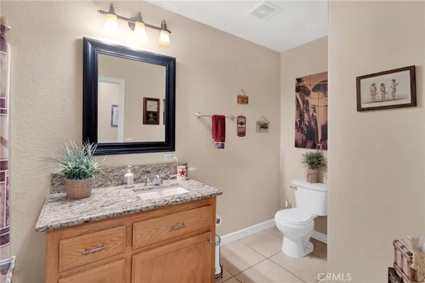 a bathroom with a granite countertop shower a mirror and a sink