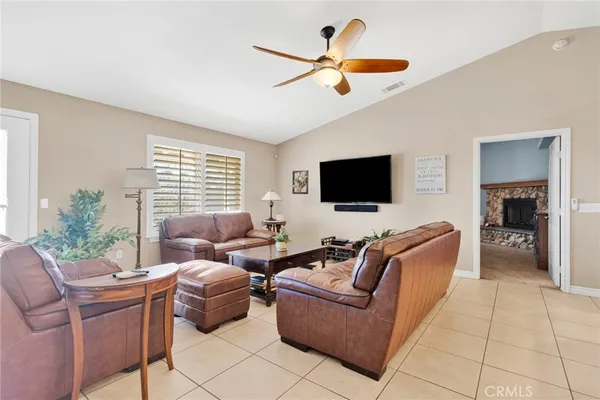a living room with furniture ceiling fan and a flat screen tv