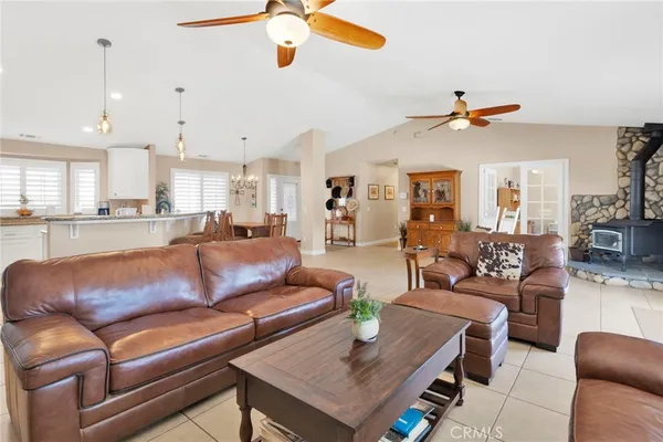 a living room with furniture kitchen view and a chandelier