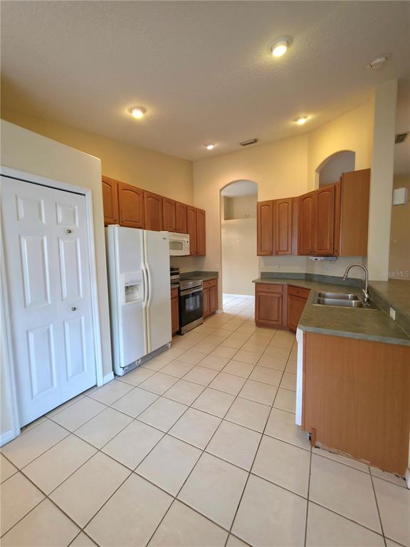 5465 High Pasture Way Melbourne, FL 32940 - Photo 12 of 39 a large kitchen with a sink and stainless steel appliances