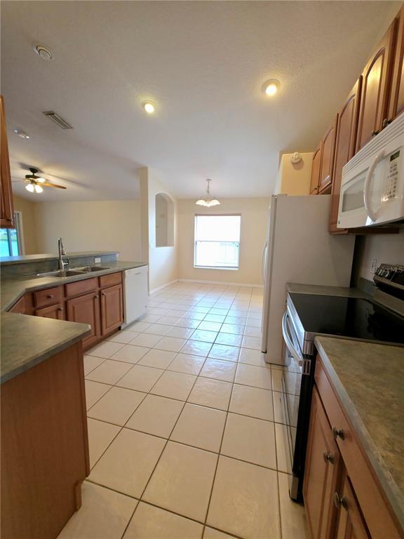 5465 High Pasture Way Melbourne, FL 32940 - Photo 13 of 39 a kitchen with stainless steel appliances granite countertop a sink and a stove