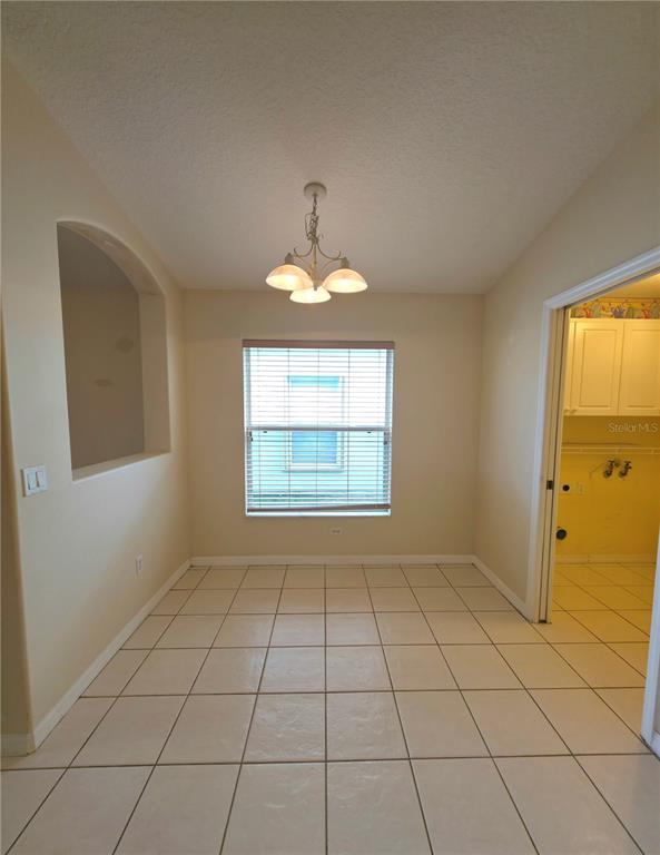 5465 High Pasture Way Melbourne, FL 32940 - Photo 14 of 39 an empty room with windows and chandelier