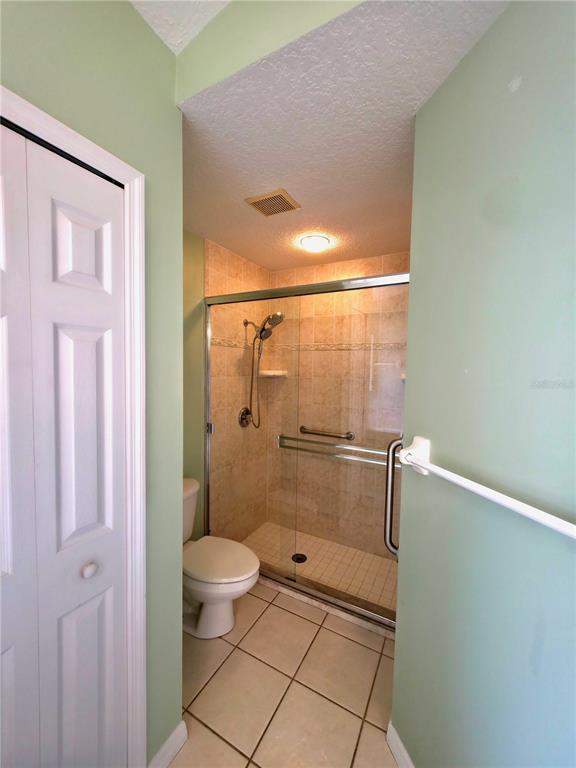 5465 High Pasture Way Melbourne, FL 32940 - Photo 18 of 39 a bathroom with a granite countertop shower a toilet and a sink