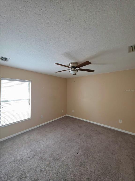 5465 High Pasture Way Melbourne, FL 32940 - Photo 22 of 39 an empty room with a window and a fan