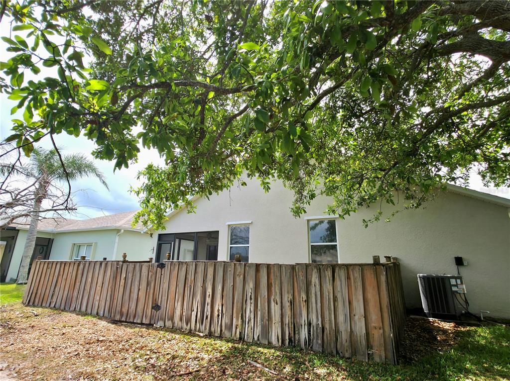 5465 High Pasture Way Melbourne, FL 32940 - Photo 30 of 39 a view of a house with wooden fence and trees