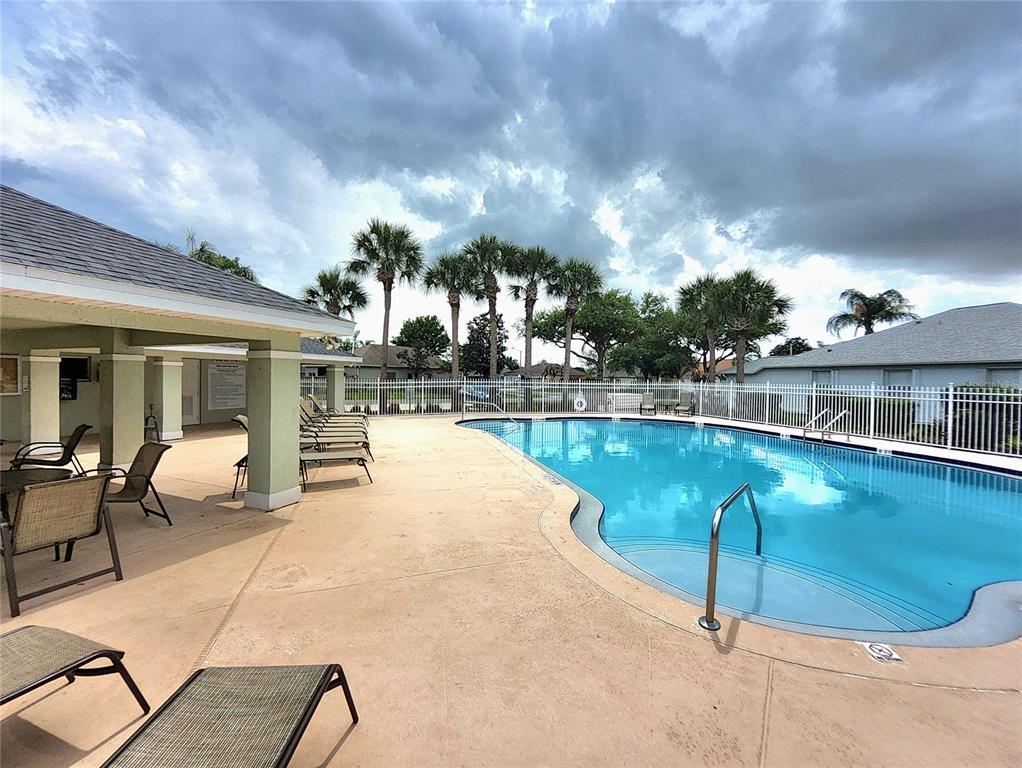 5465 High Pasture Way Melbourne, FL 32940 - Photo 34 of 39 a swimming pool with outdoor seating and yard in back