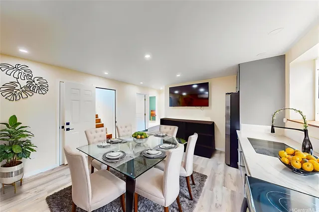 a view of a dining room with furniture a potted plant and wooden floor