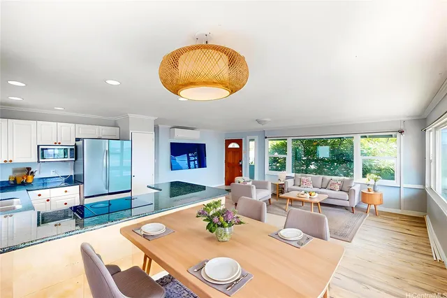 a living room with stainless steel appliances granite countertop furniture a couch and a large window