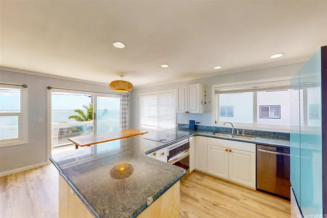 a kitchen with stainless steel appliances granite countertop a sink and a stove