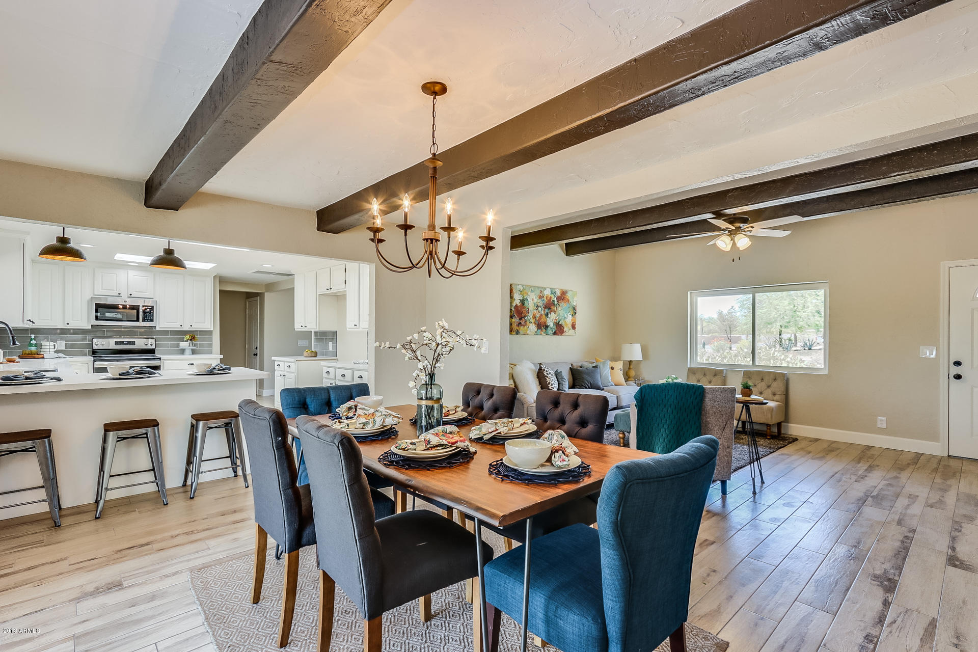521 South Geronimo Road Apache Junction, AZ 85119 - Photo 16 of 40 a dining room with wooden floor a chandelier a wooden table and chairs
