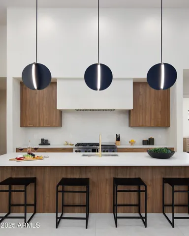 a kitchen with stainless steel appliances granite countertop a sink a stove and a wooden floors