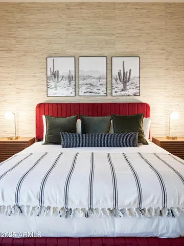 a bedroom with a bed and painting on the wall