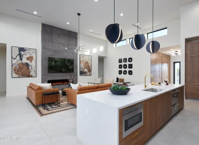 a kitchen with a stove a microwave and a view of living room