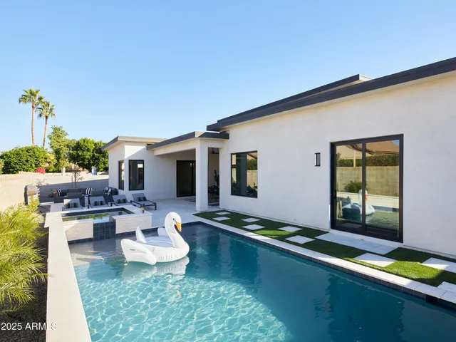 a kitchen with a sink stainless steel appliances and chairs