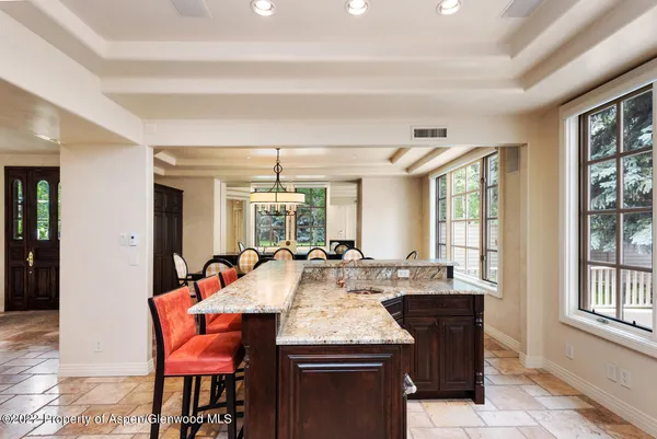 a dining hall with stainless steel appliances granite countertop a stove and a dining table chair