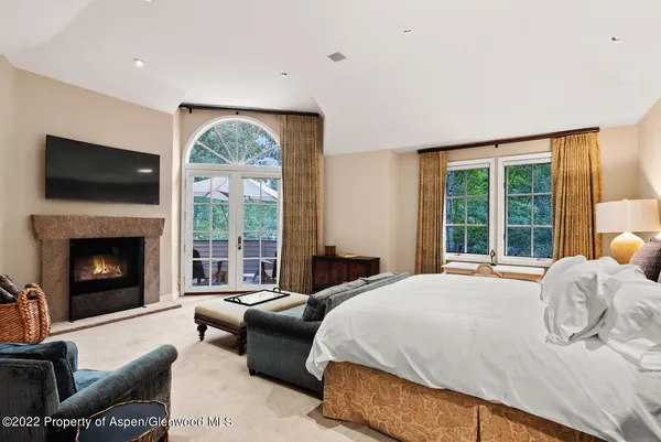 a bedroom with a bed and a large window