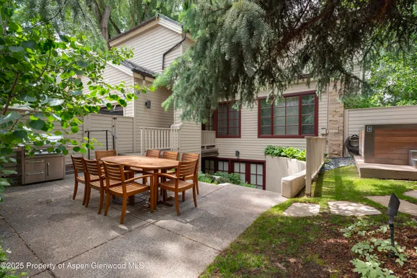 a view of a house with backyard and sitting area
