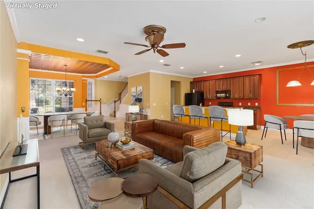 a living room with furniture kitchen view and a large window