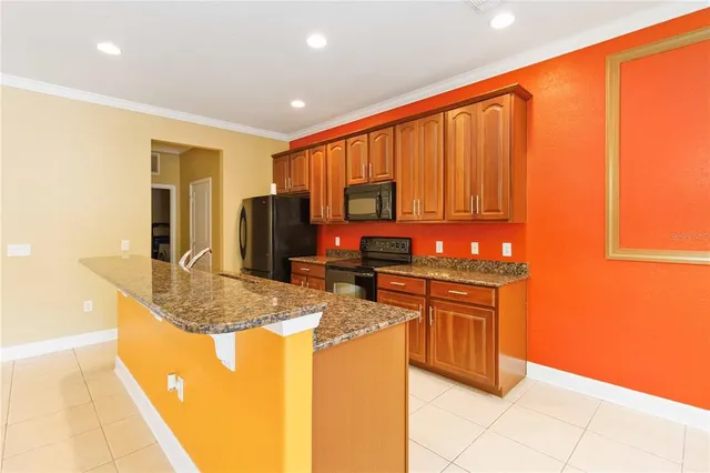 a kitchen with granite countertop a refrigerator stove and sink