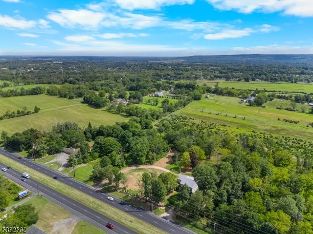 an aerial view of a house with yard and swimming pool
