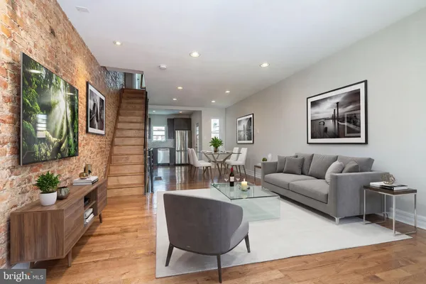 a living room with furniture kitchen view and a large window