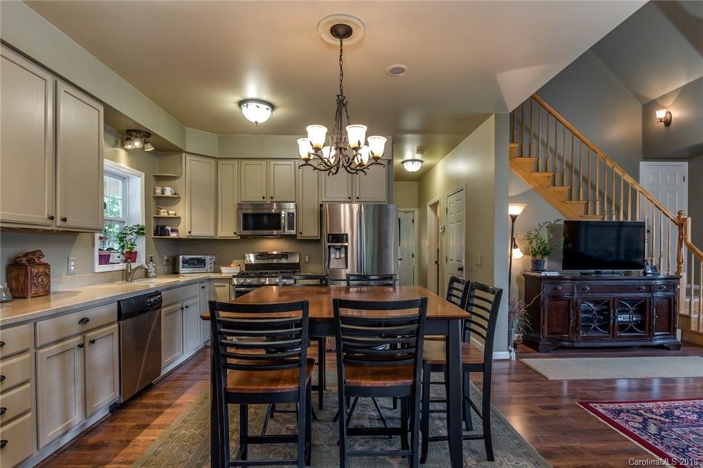 1588 McEntire Road Tryon, NC 28782 - Photo 5 of 27 a kitchen with stainless steel appliances a table chairs and a refrigerator