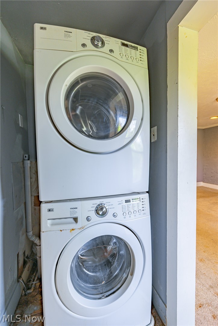 39016 Detroit Road Avon, OH 44011 - Photo 26 of 36 Laundry area with stacked washer and dryer and carpet floors
