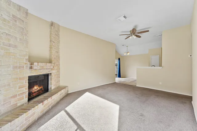 a view of empty room with fireplace and wooden floor