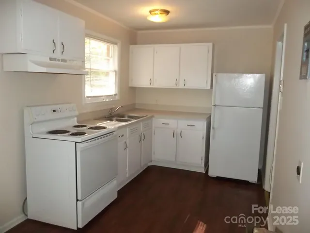 a kitchen with a sink cabinets appliances and a window