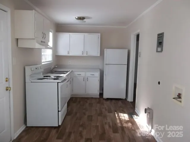 a kitchen with a refrigerator a stove top oven a sink and cabinets