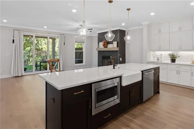 a kitchen with stainless steel appliances kitchen island a sink stove and cabinets
