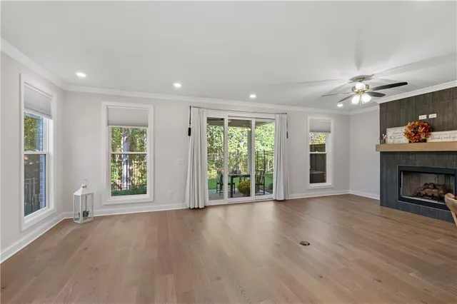 a view of an empty room with a window and fireplace