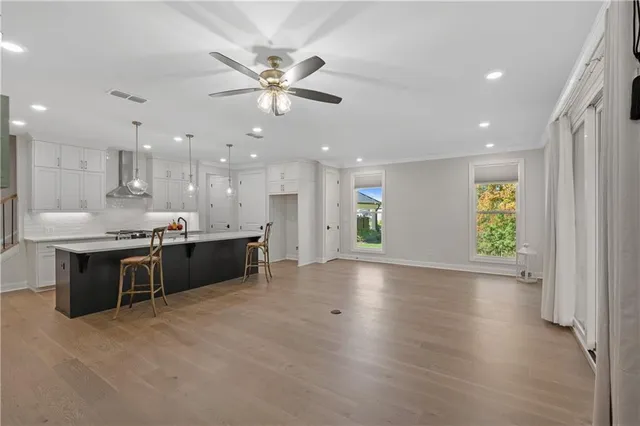 a large kitchen with stainless steel appliances kitchen island a large counter top and a wooden floors